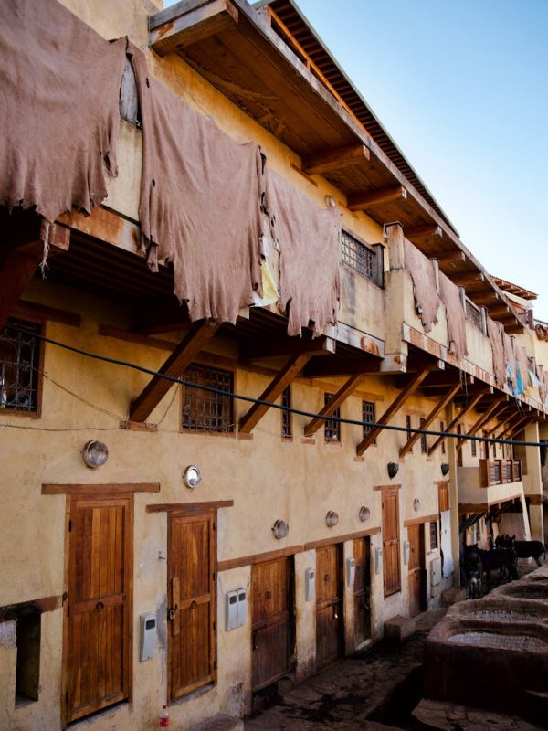 10 Day Morocco Tour From Casablanca 8 Rustic facade of a traditional tannery in Fes, Morocco, showcasing drying fabrics.
