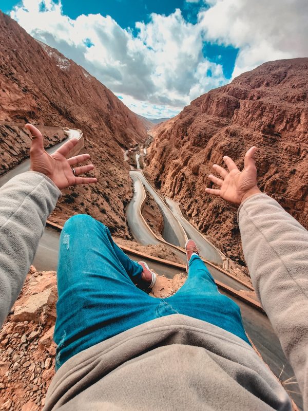 3-Days Marrakech to Merzouga Dunes Desert Tour with Camel Trek 5 person in gray pants sitting on brown rock formation during daytime